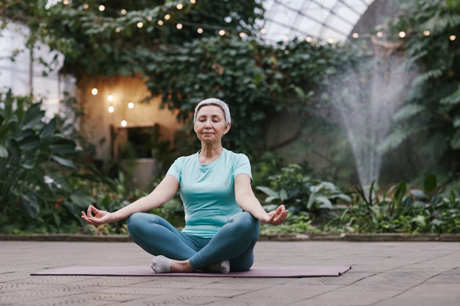 Elderly woman meditating in serene botanical garden setting.