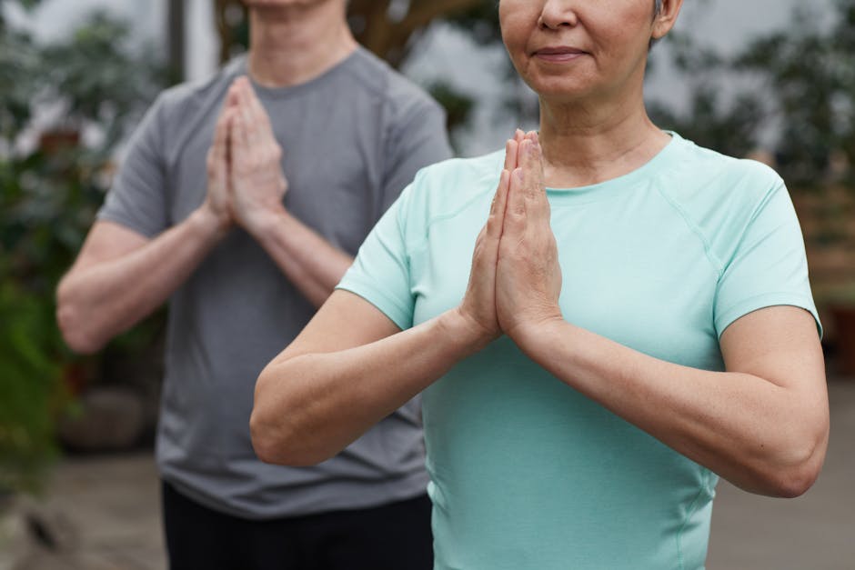 Senior couple in a meditative yoga pose outdoors, promoting wellness.