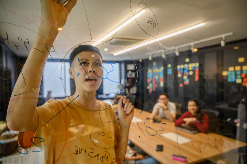 Team collaboratively brainstorming on transparent board in a modern office setting