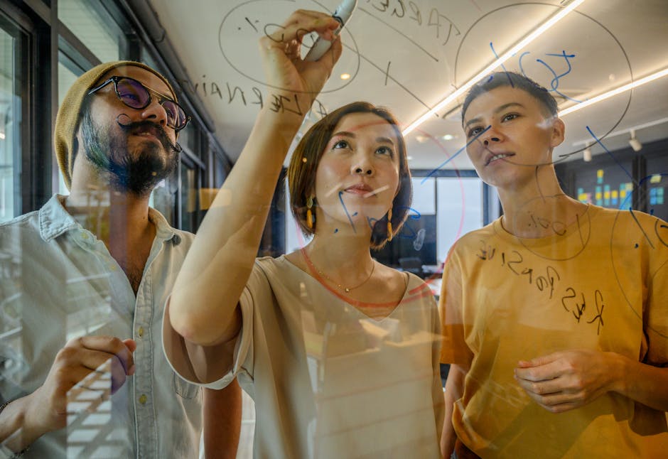 Group of diverse professionals collaborating on a glass board in a modern office setting