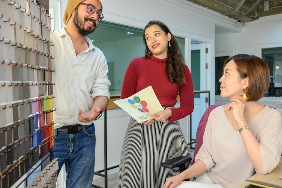 Three colleagues discussing design concepts in a contemporary office setting